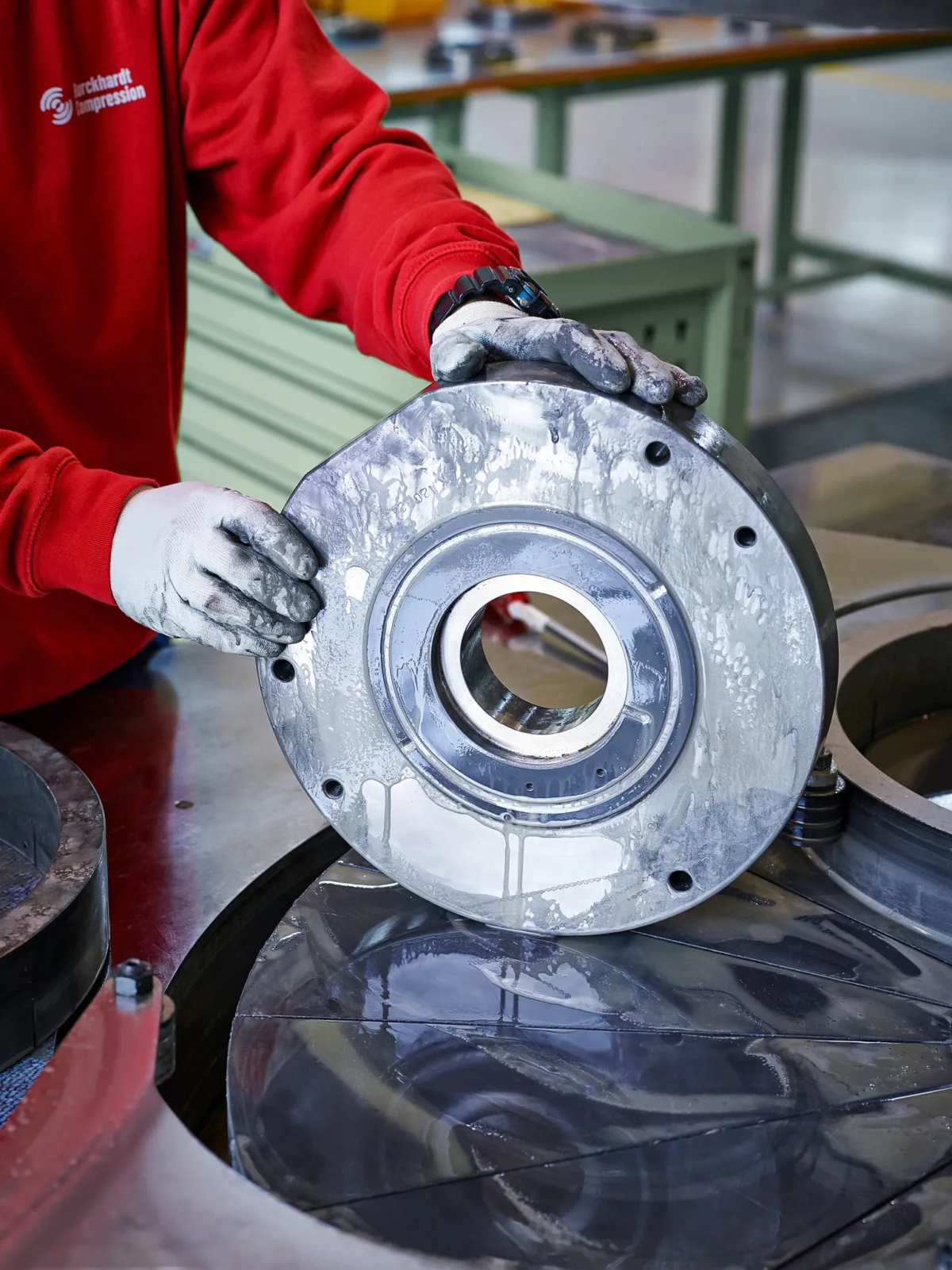 Workers hands positioning a machined compressor component in production, Burckhardt Compression, Ningbo, China, industrial photography by Scanderbeg Sauer