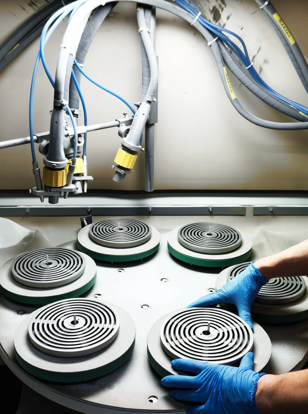 Gloved hands assembling reciprocating compressor valves, Burckhardt Compression, Winterthur, industrial photography by Scanderbeg Sauer