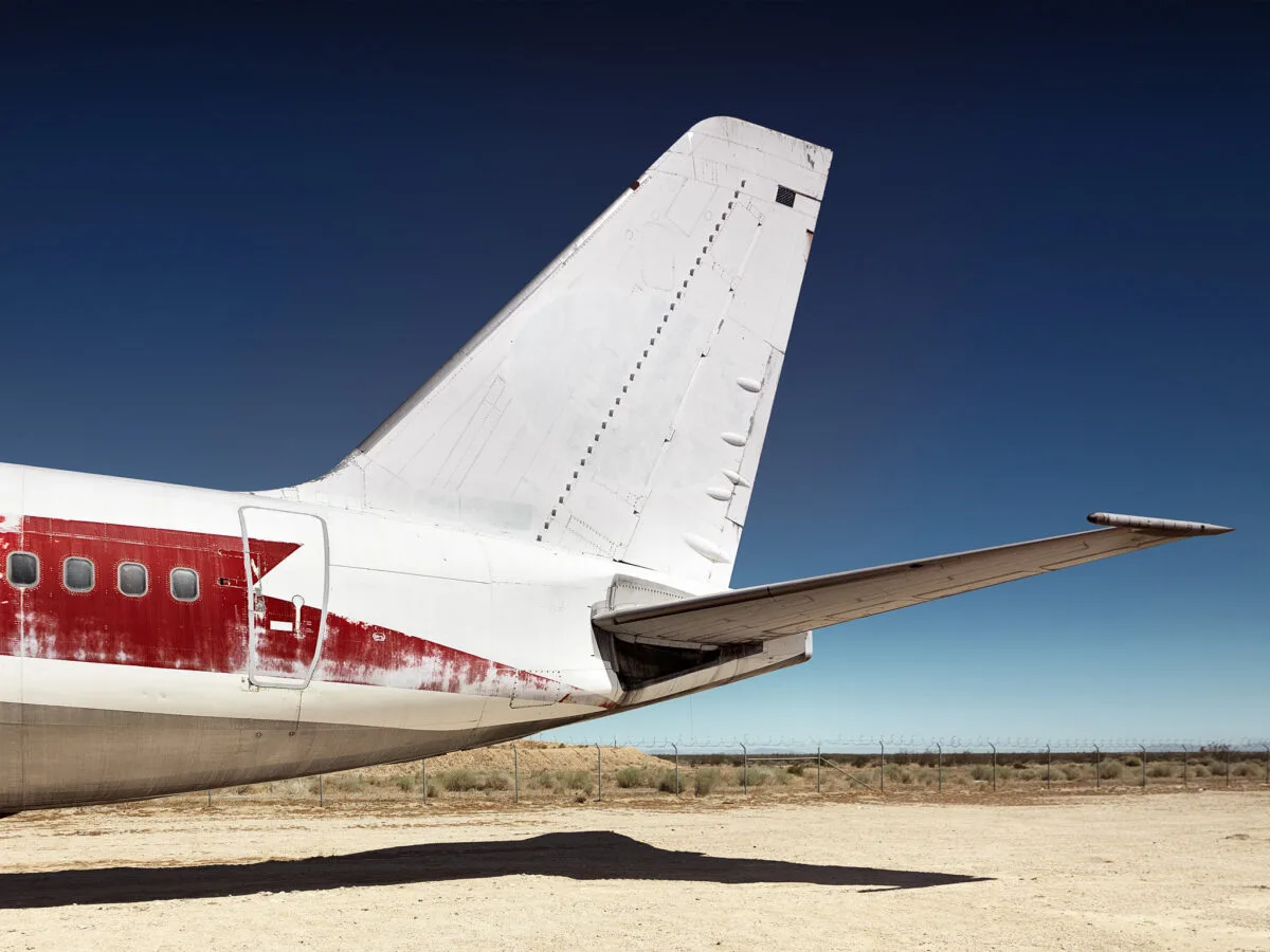 Tail section of decommissioned aircraft with red livery, Mojave Desert, Scanderbeg Sauer – DECOMMISSIONED LAX-MHV