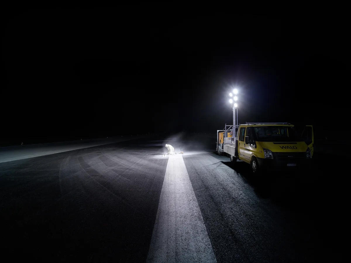 Service vehicle and floodlights on the runway at night during resurfacing works at Zurich Airport, engineering photography by Scanderbeg Sauer