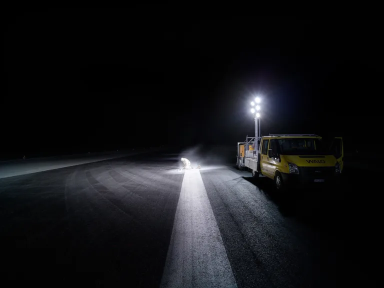 Service vehicle and floodlights on the runway at night during resurfacing works at Zurich Airport, engineering photography by Scanderbeg Sauer