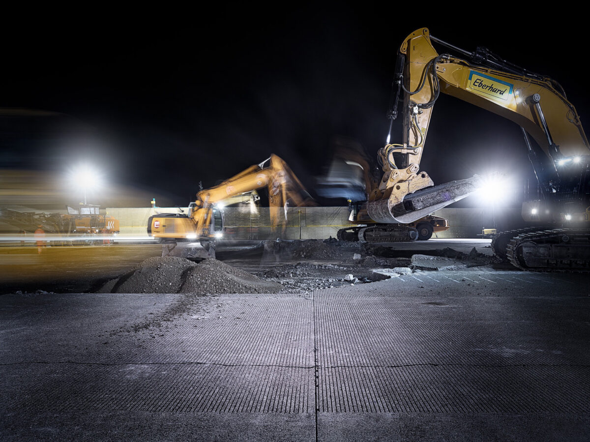 Excavators during nighttime resurfacing of the runway at Zurich Airport, engineering photography by Scanderbeg Sauer