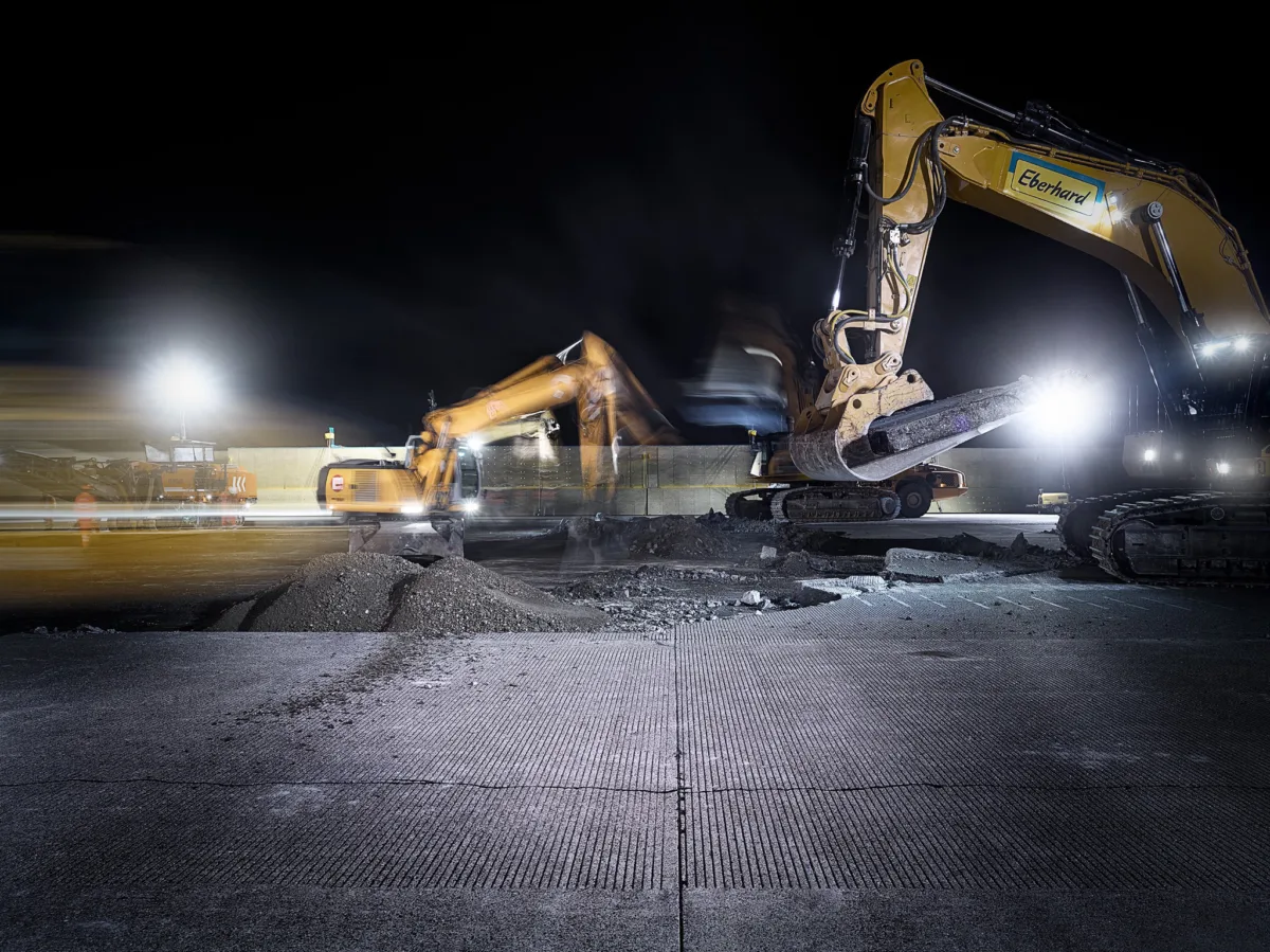 Excavators during nighttime resurfacing of the runway at Zurich Airport, engineering photography by Scanderbeg Sauer