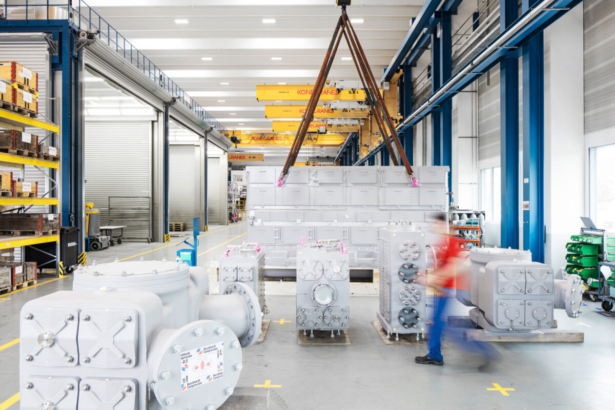 Finished compressor packages staged in the assembly hall with overhead crane, Burckhardt Compression, Winterthur, industrial photography by Scanderbeg Sauer