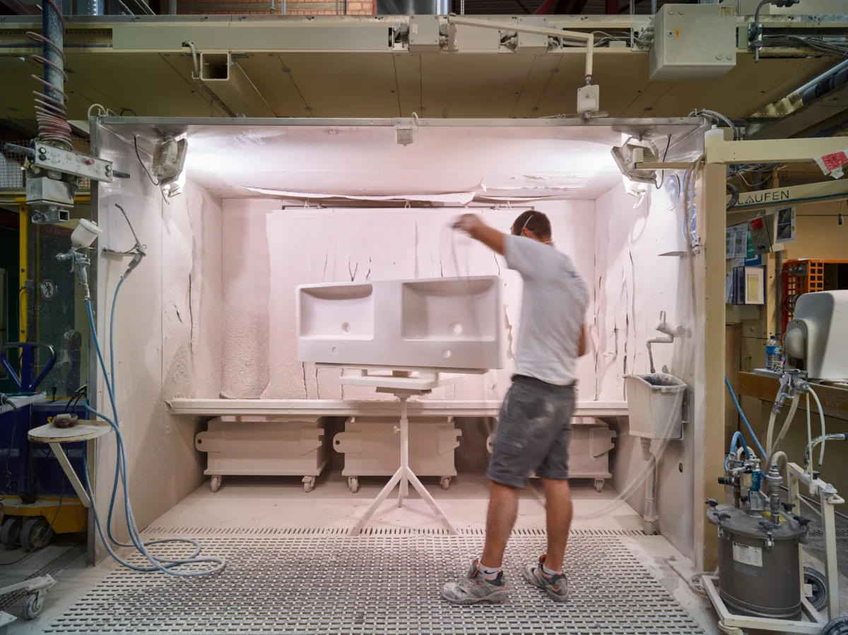Mitarbeiter beim Spritzen eines Lavabos im Spritzwerk, Keramik Laufen, Laufen, Schweiz, Industriefotografie von Scanderbeg Sauer