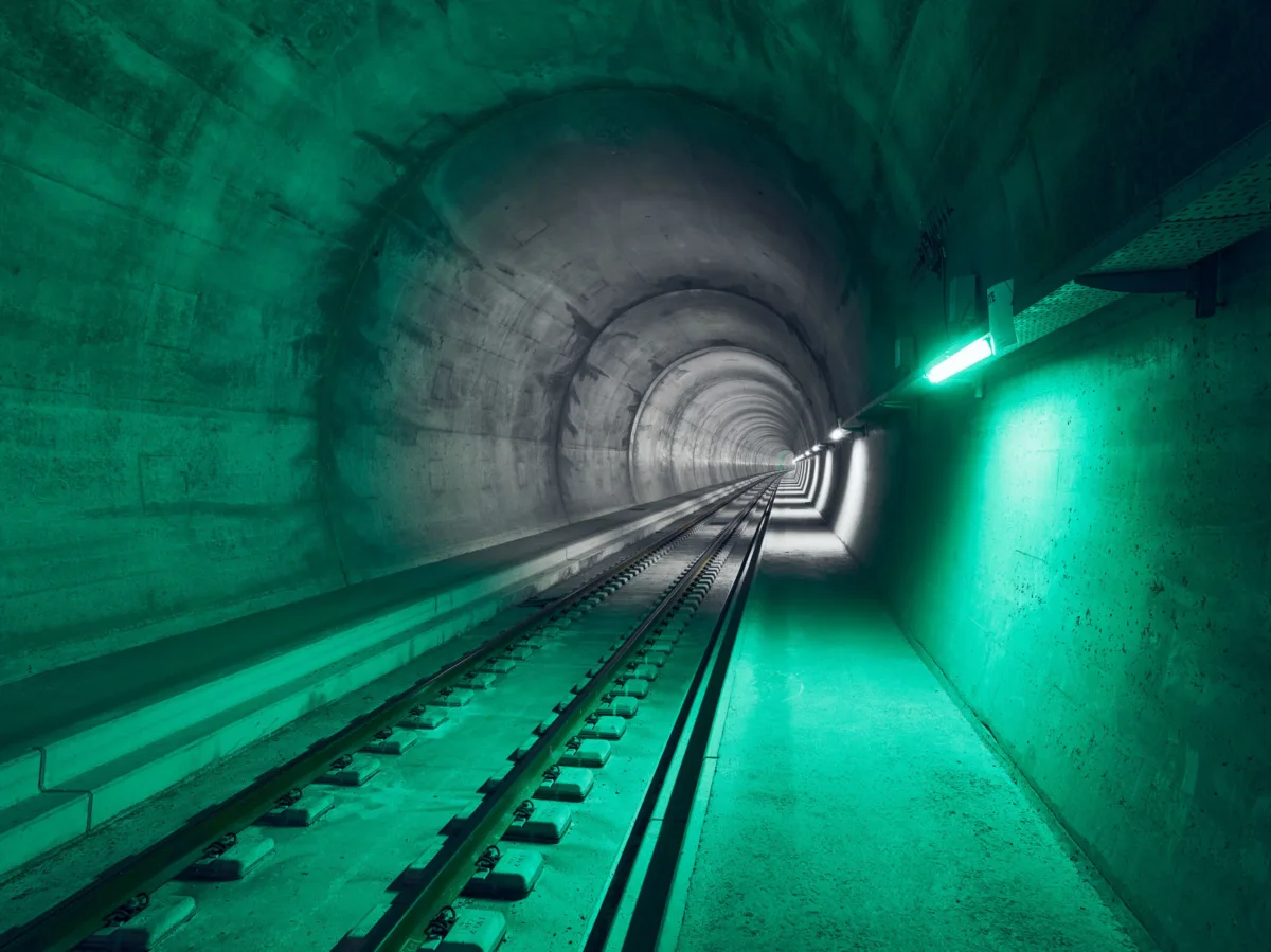 Tunnelröhre mit Gleis und grüner Beleuchtung, Ceneri-Basistunnel, Tessin, Schweiz, Infrastrukturfotografie von Scanderbeg Sauer