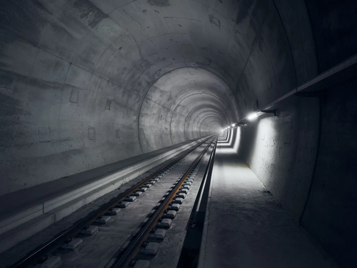 Tunnelröhre mit Gleis und Licht am Tunnelende, Ceneri-Basistunnel, Tessin, Schweiz, Infrastrukturfotografie von Scanderbeg Sauer