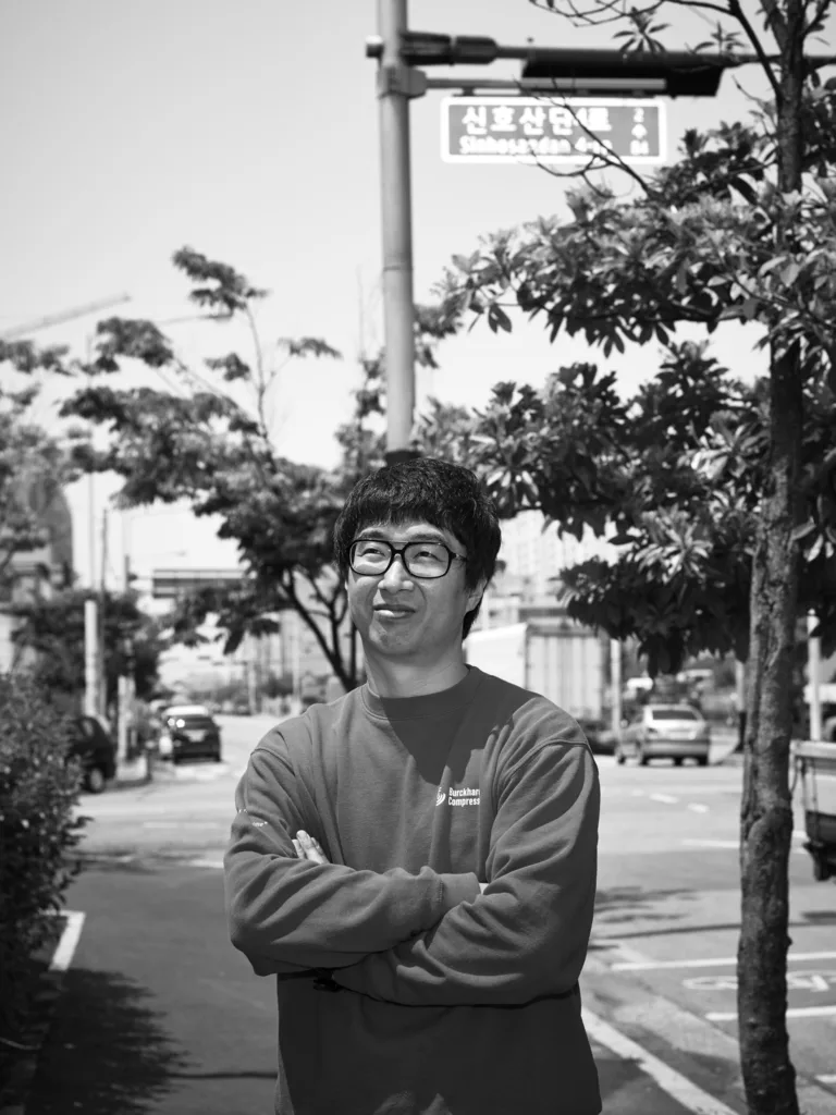 Black-and-white employee portrait on a street in Busan, Burckhardt Compression, South Korea, corporate photography by Scanderbeg Sauer