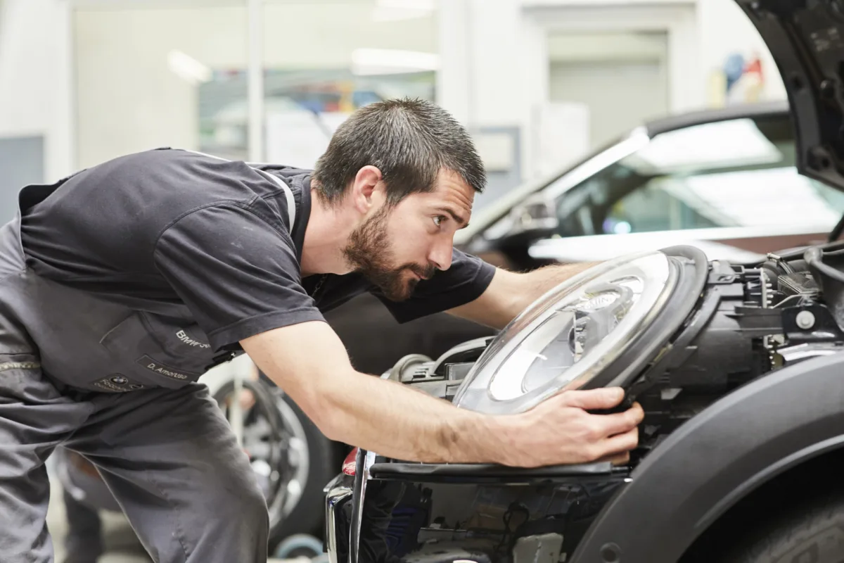 Servicetechniker bei der Arbeit am Fahrzeug bei MINI Schweiz, Unternehmensfotografie von Scanderbeg Sauer