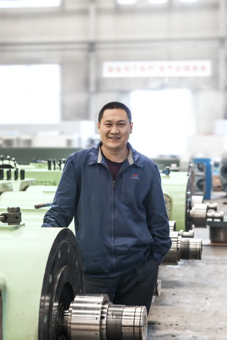 Employee portrait in the workshop with machined components, Shenyang Yuanda Compressor, Shenyang, China, industrial photography by Scanderbeg Sauer