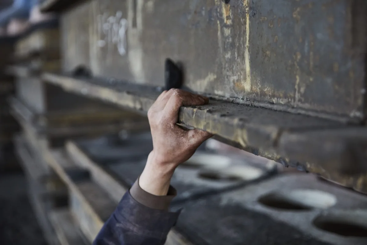 Workers hand finishing a casting mould in the foundry, Shenyang Yuanda Foundry, Shenyang, China, industrial photography by Scanderbeg Sauer