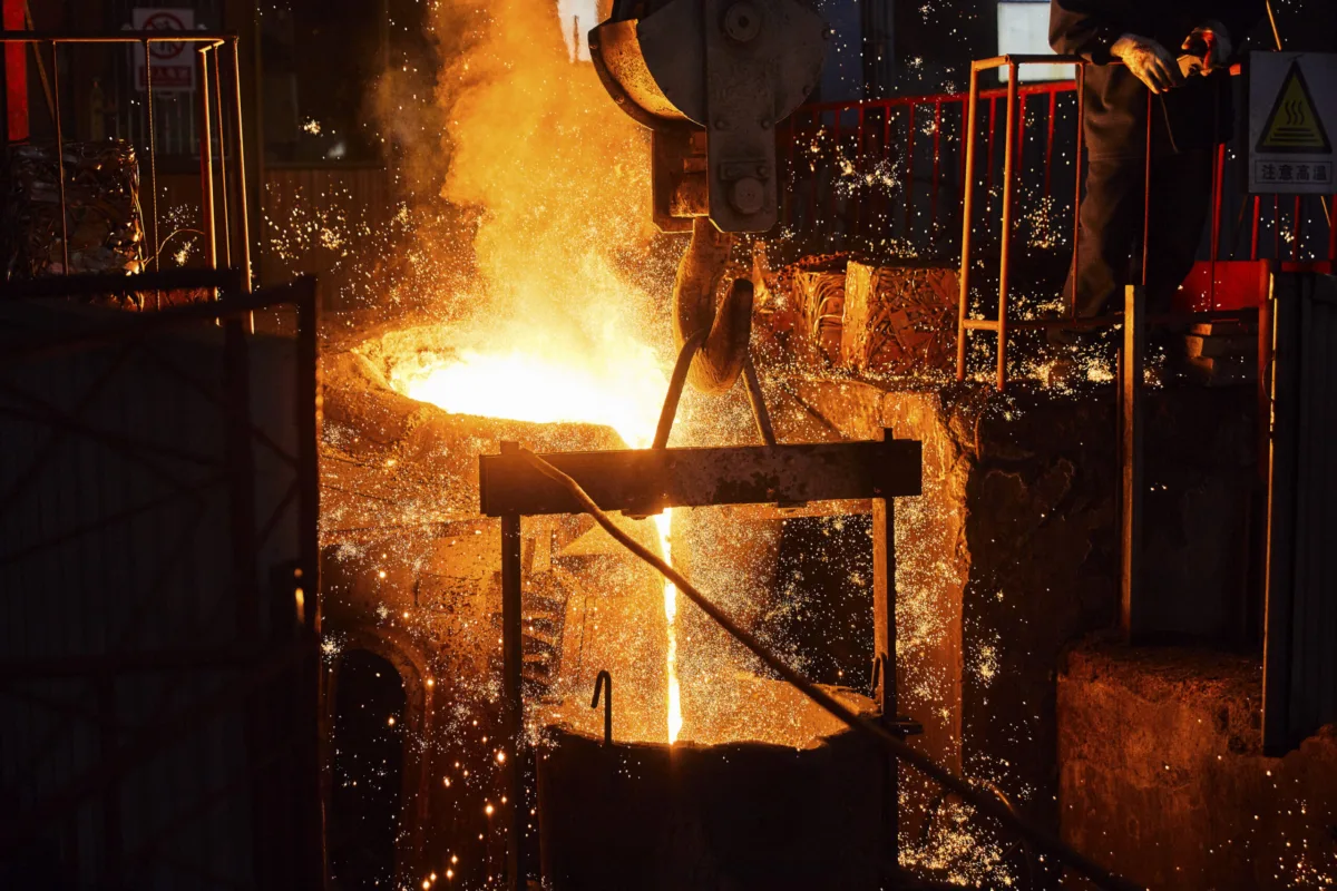 Molten iron pouring with sparks during casting in the foundry, Shenyang Yuanda Foundry, Shenyang, China, industrial photography by Scanderbeg Sauer