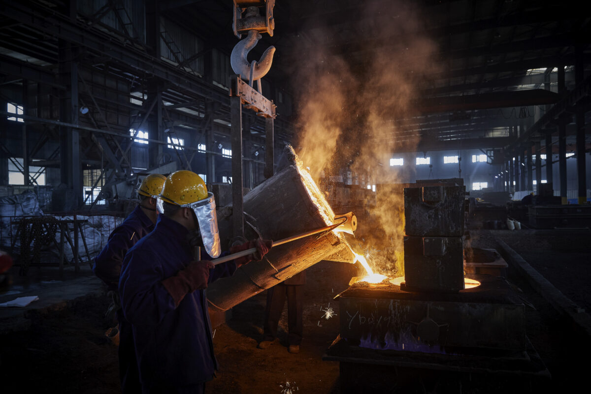 Workers pouring molten metal during casting in the foundry, Shenyang Yuanda Foundry, Shenyang, China, industrial photography by Scanderbeg Sauer