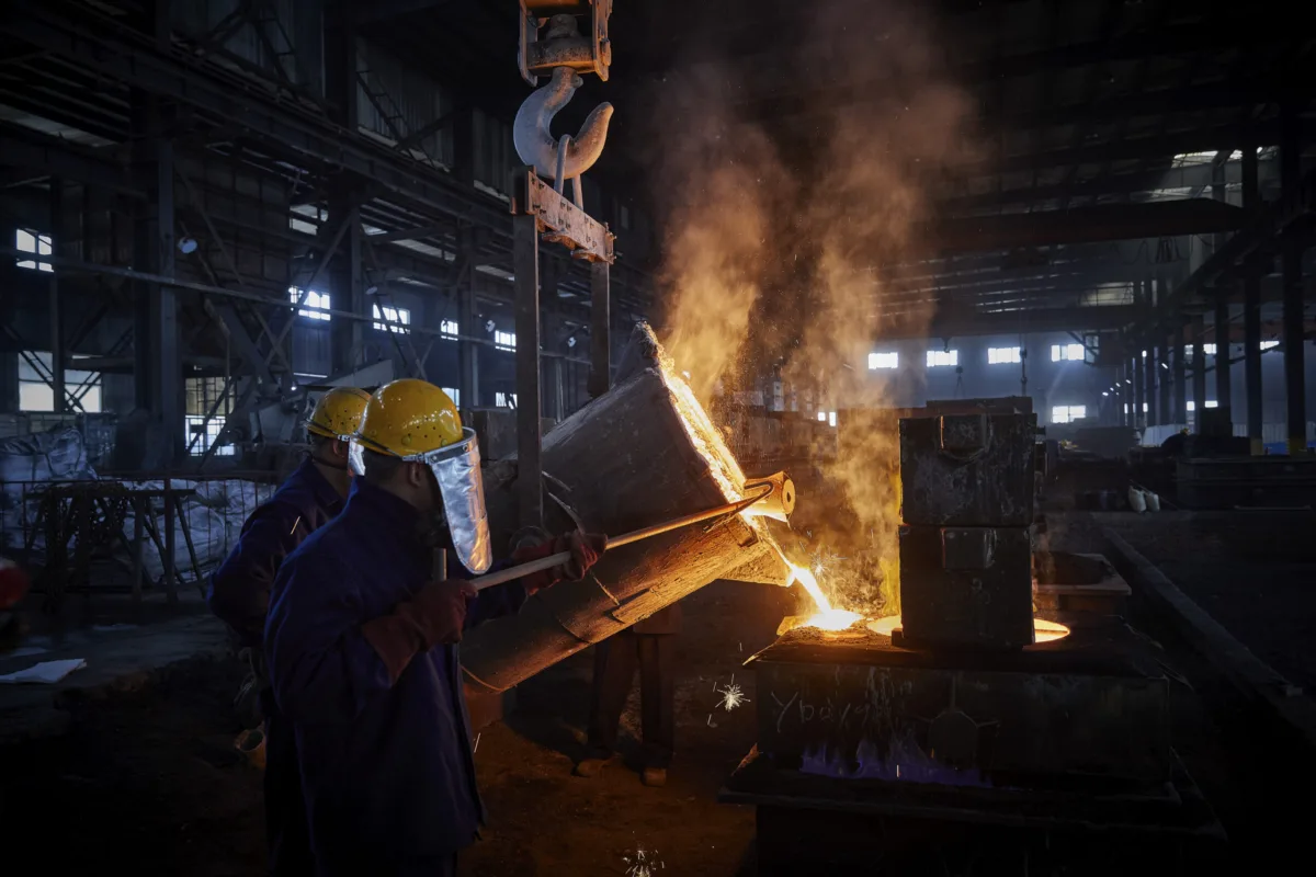 Workers pouring molten metal during casting in the foundry, Shenyang Yuanda Foundry, Shenyang, China, industrial photography by Scanderbeg Sauer