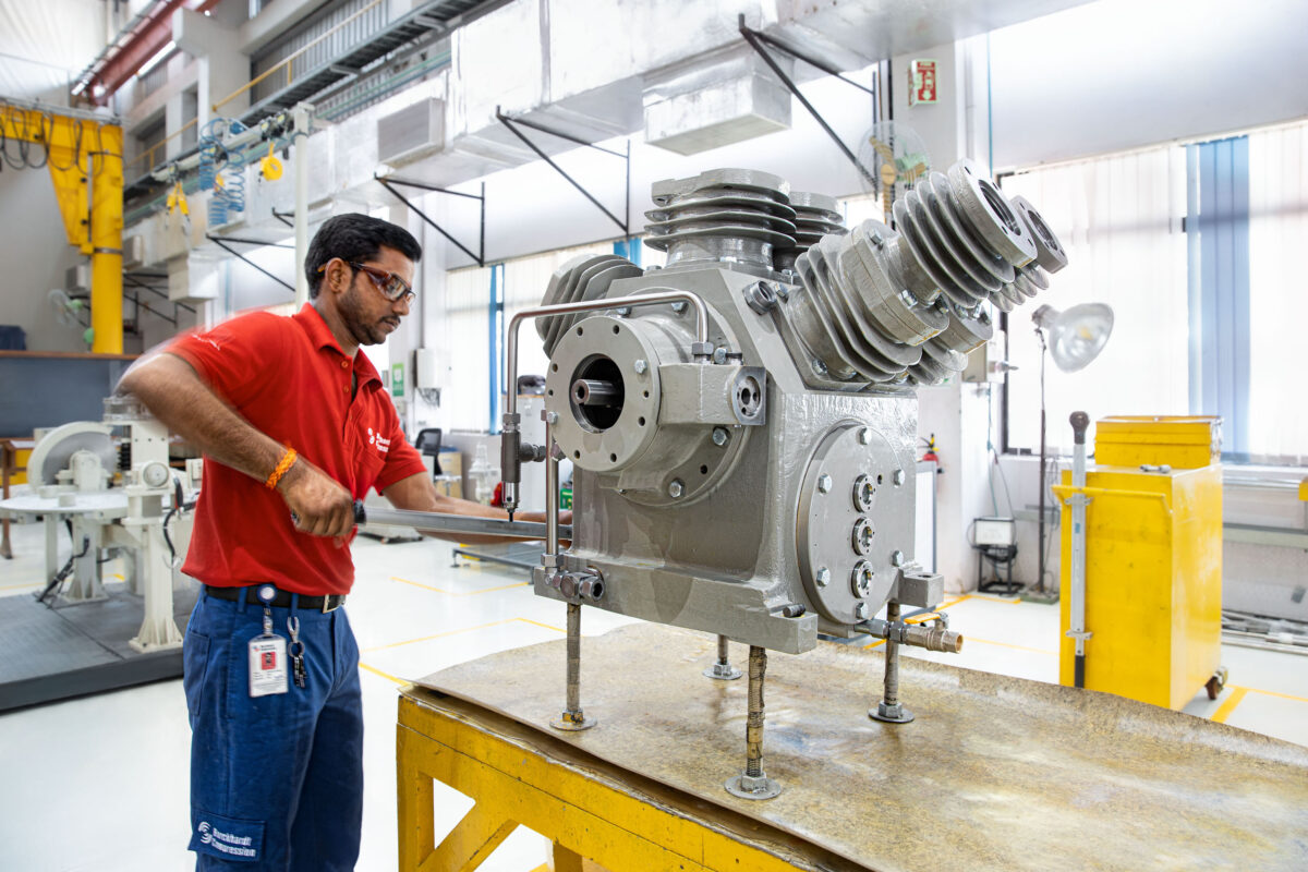 Technician assembling a compressor on the assembly line, Burckhardt Compression, Pune, India, industrial photography by Scanderbeg Sauer