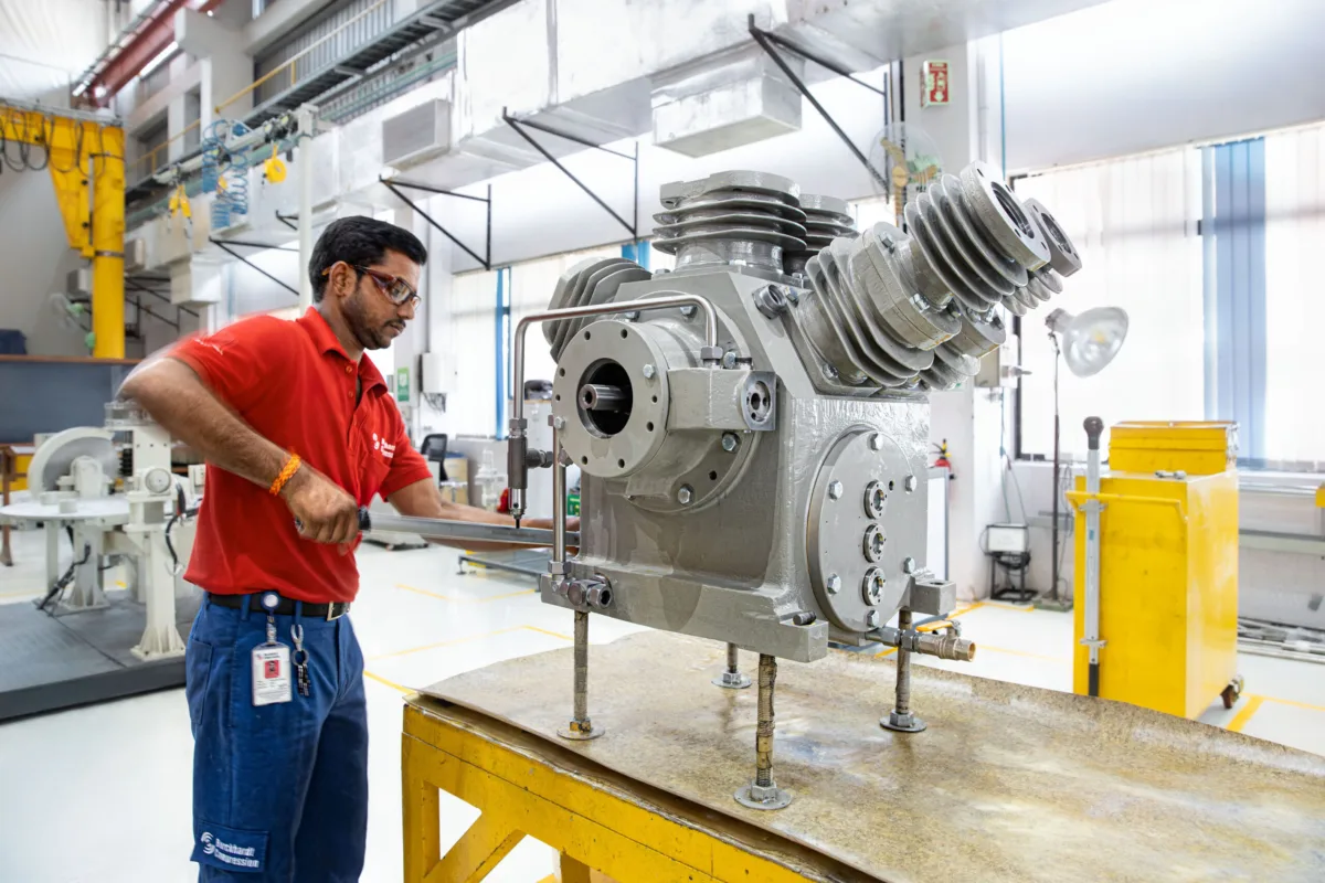 Technician assembling a compressor on the assembly line, Burckhardt Compression, Pune, India, industrial photography by Scanderbeg Sauer