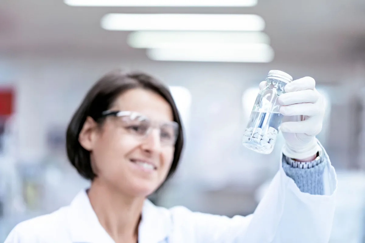 Laboratory technician with vial, Datwyler, Alken, Belgium, corporate photography by Scanderbeg Sauer