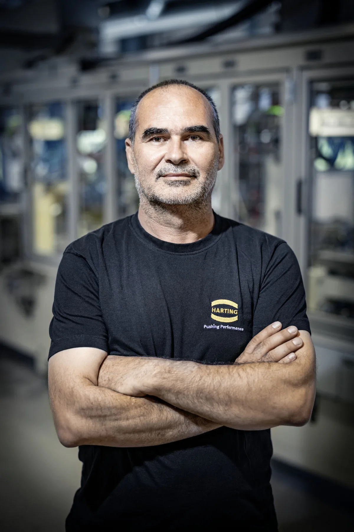 Portrait eines Mitarbeiters mit verschränkten Armen bei Harting Biel, Unternehmensfotografie von Scanderbeg Sauer
