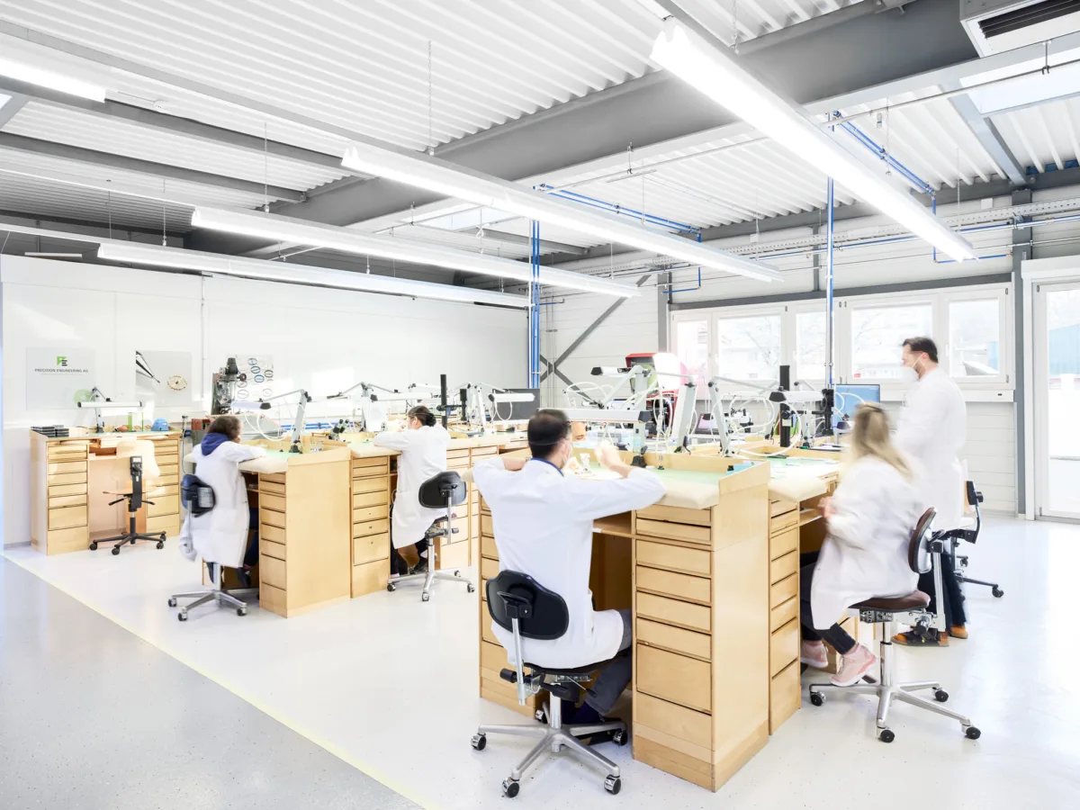 Watchmaking photography, H. Moser & Cie. watchmakers at workbenches in atelier, Schaffhausen, by Scanderbeg Sauer