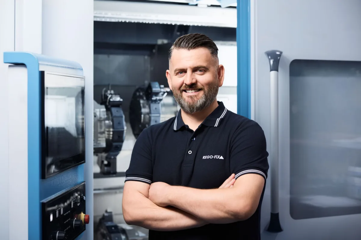 Mitarbeiterportrait vor CNC-Maschine bei Rego-Fix Tenniken, Unternehmensfotografie von Scanderbeg Sauer