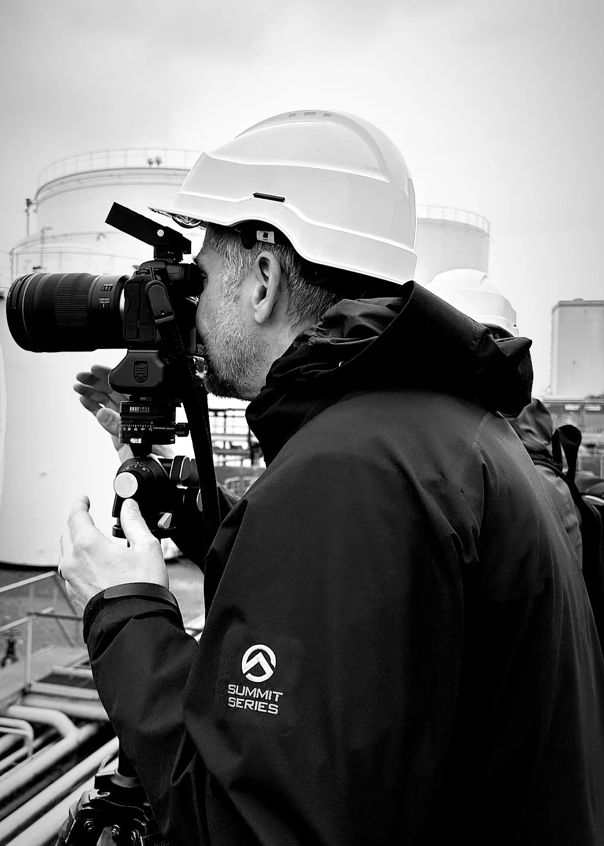 Fotograf mit Schutzhelm und Kamera auf dem Werksgelände von Ambrian Energy in Bremen