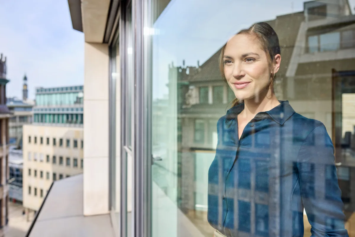 Office portrait of an employee at the window, Ambrian Energy Hamburg, corporate photography by Scanderbeg Sauer
